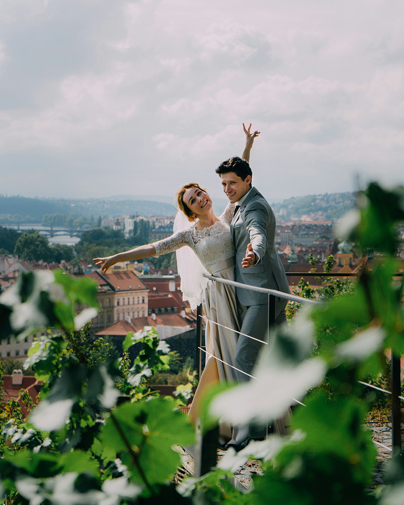 Wedding photo of a couple posing over a balcony.